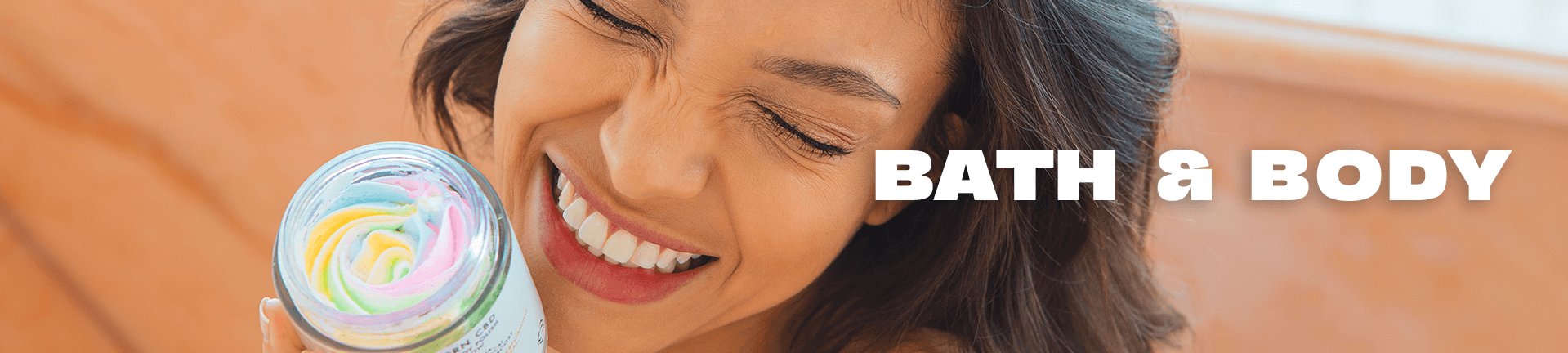 A smiling woman holds a jar of colorful, swirled bath product next to her face. The words BATH & BODY are written in bold white text beside her.