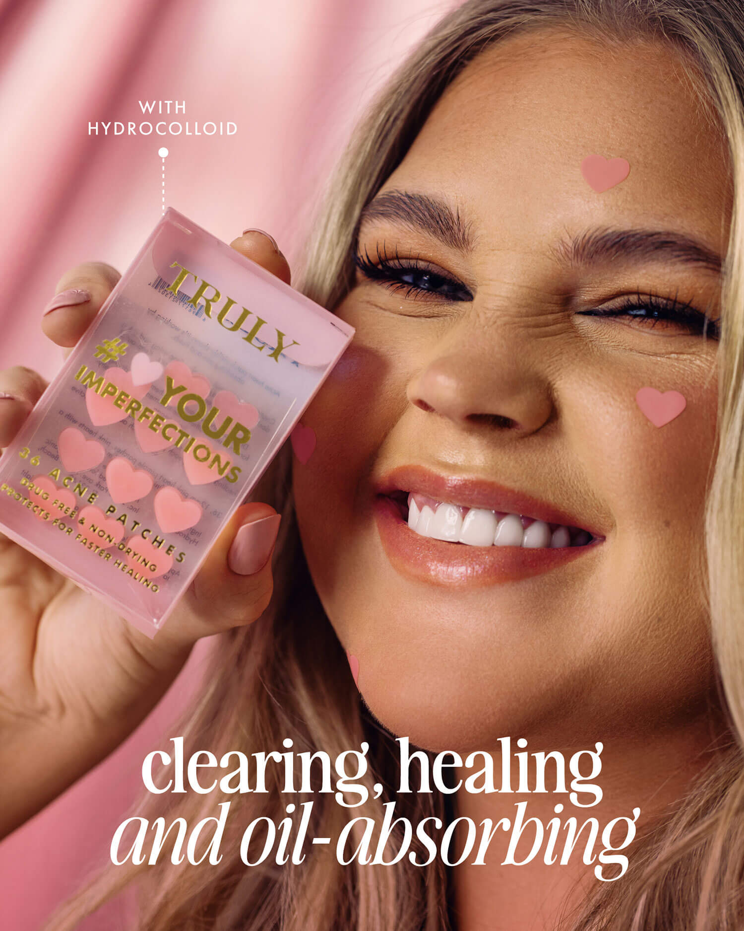 A smiling person holds Truly Beauty’s #Heart Your Imperfections Blemish Patches by their face. Pink heart stickers and heart-shaped patches decorate their cheek and the air. Text: Clearing, healing, oil-absorbing HYDROCOLLOID—your skincare essential.