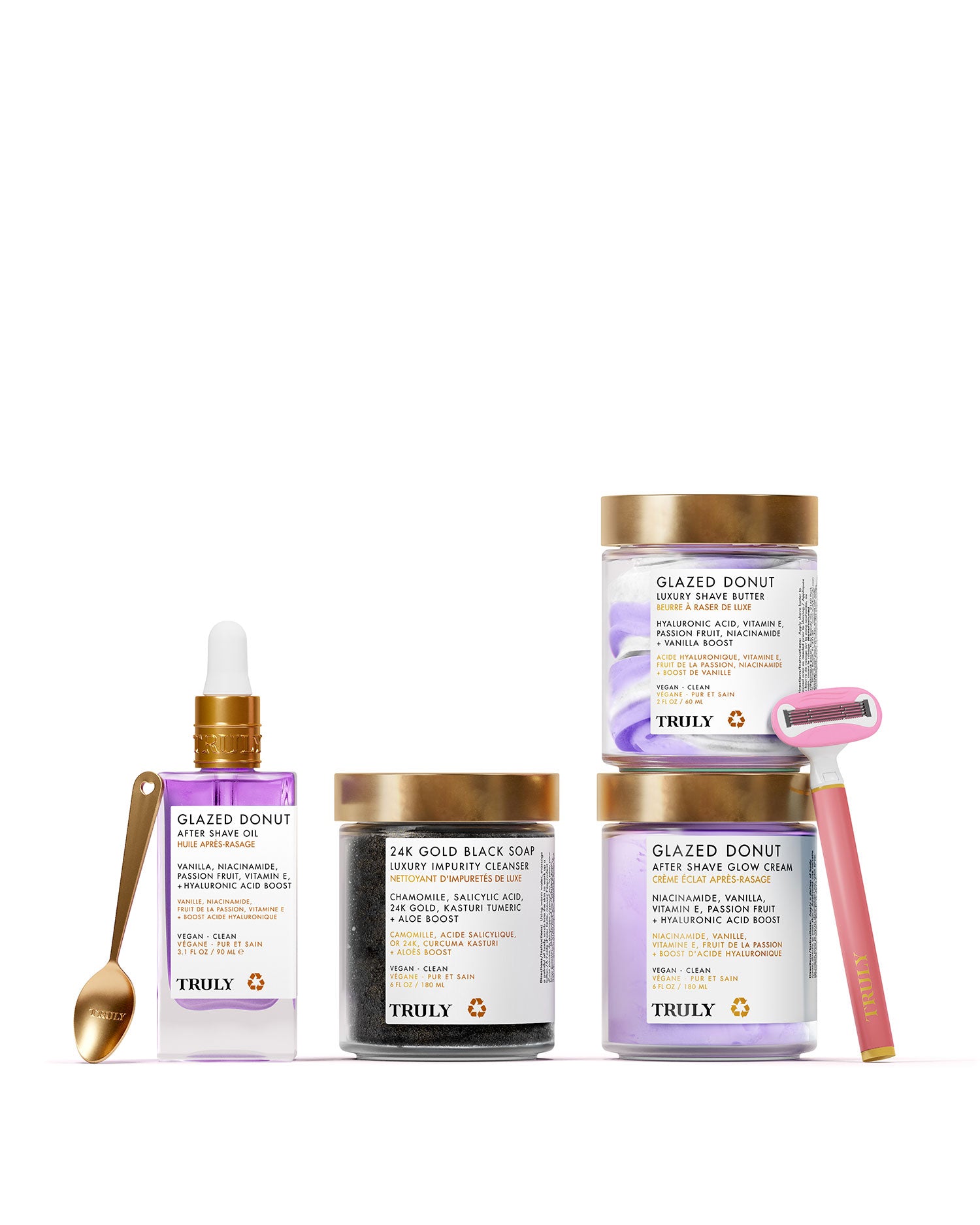 The Glazed Donut Shave Set from Truly Beauty includes After Shave Glow Cream, Soft Serve Whipped Shave Butter, a serum with dropper, black soap jar, gold razor, and gold spoon—all displayed against a pale pink background.