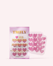 A package of Truly Beauty #Heart Your Imperfections Blemish Patches, featuring pink heart-shaped patches next to the pink and gold detailed box—a cute addition to your skincare routine.