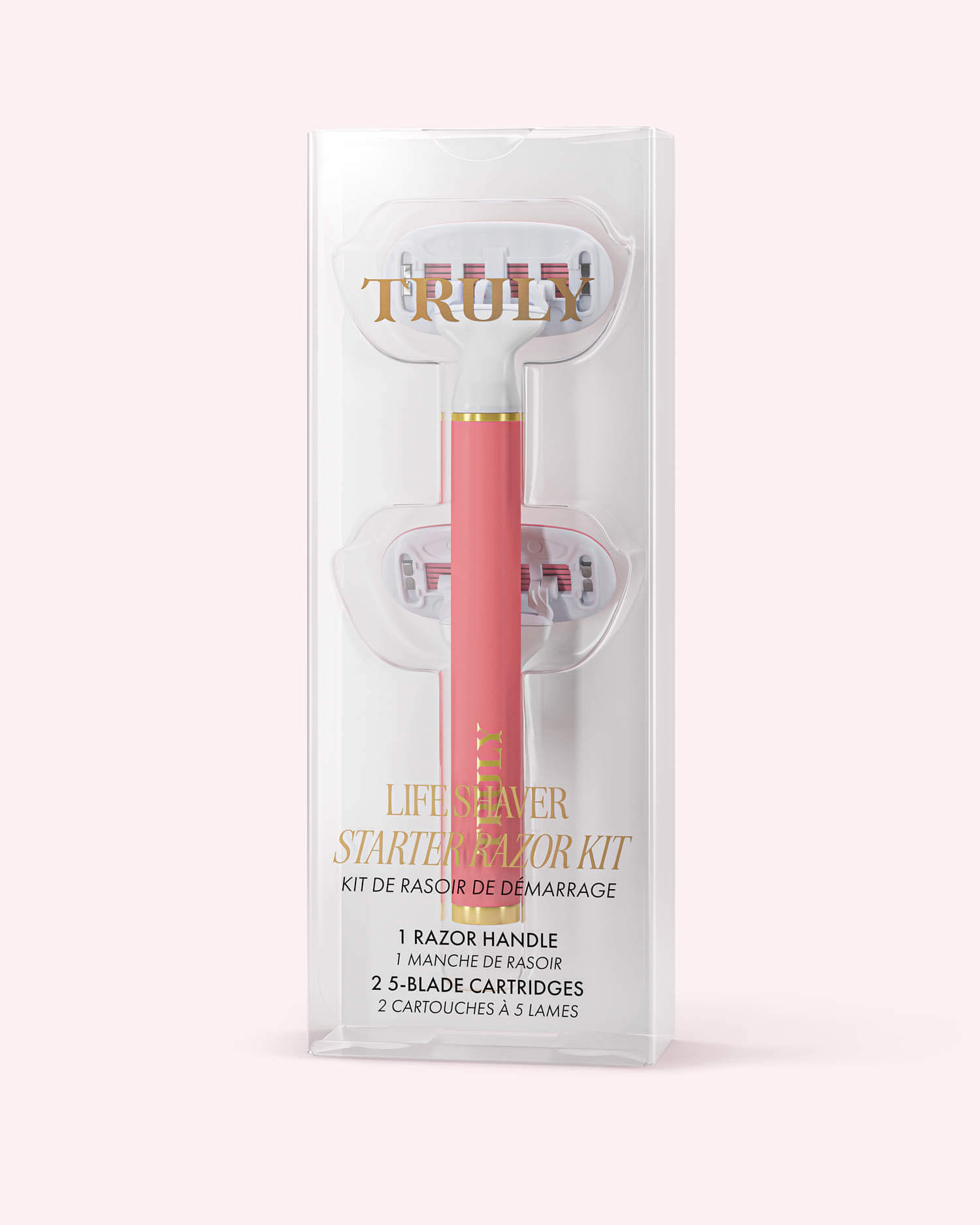 A pink razor kit in clear packaging, labeled Life Shaver Starter Razor from Truly Beauty. Made for sensitive skin, it includes a razor handle and two 5-blade cartridges. Set against a light pastel pink background.