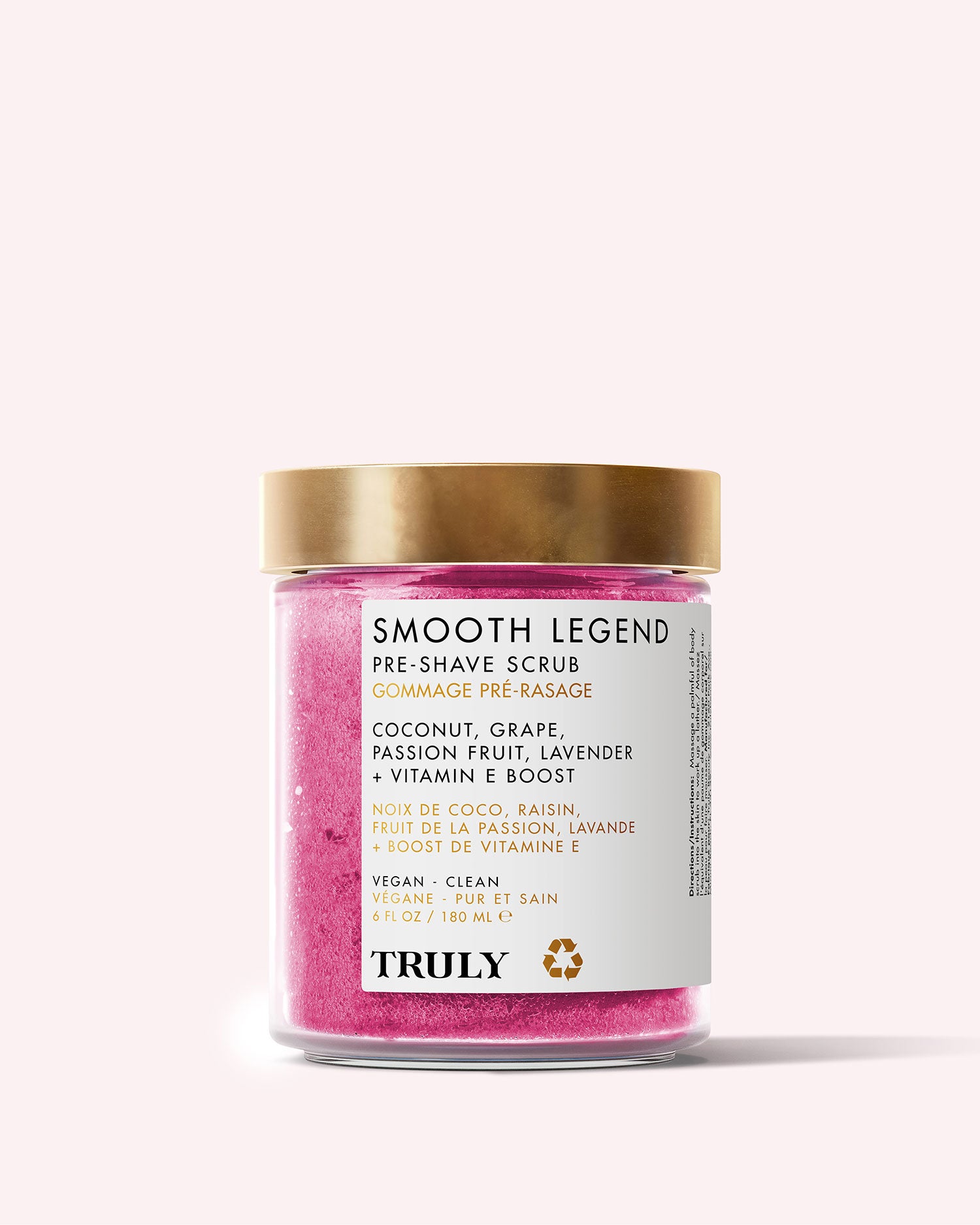 The Smooth Legend Pre-Shave Scrub by Truly Beauty comes in a pink jar with a gold lid and white label, featuring clean, vegan ingredients like coconut, grape, passion fruit, lavender, and Vitamin E for glowing skin.
