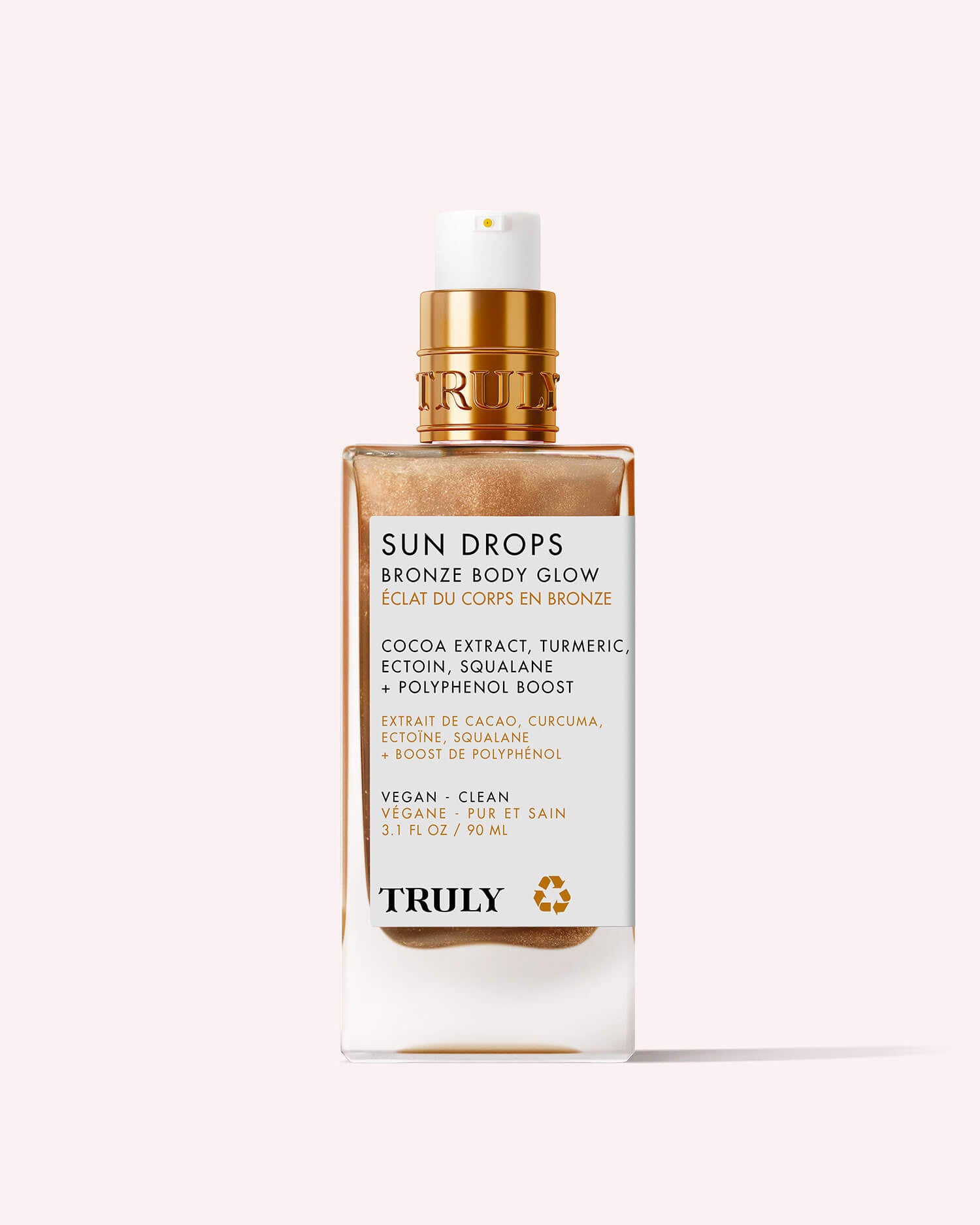 A 3.1 fl oz Sun Drops Bronze Body Glow by Truly Beauty, a hydrating bronzing oil with cocoa extract, turmeric, and squalane. Features a gold pump, white label with gold text, and delivers a sunkissed glow.