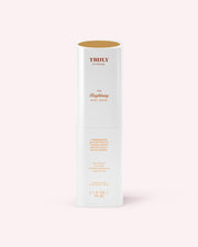 A white cylindrical bottle labeled Truly Beauty The Brightening Body Serum (3.1 fl oz/90 mL), designed to target dark spots and hyperpigmentation, stands upright against a pale pink background with gold and pink text.