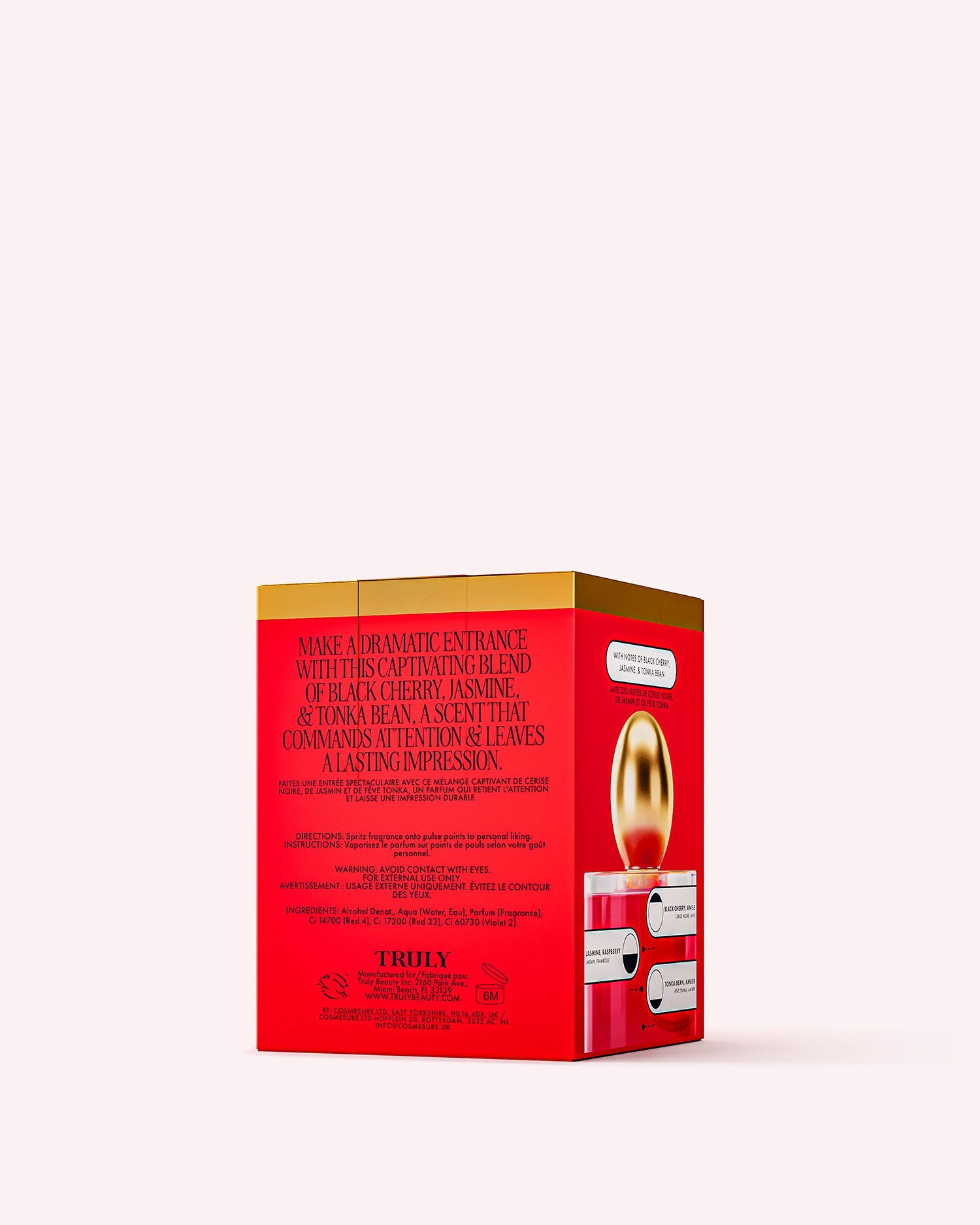 A rectangular red and gold box displays Truly Beautys Cherry Baby Eau De Parfum, highlighting black cherry and jasmine notes on its sides, set against a light pink background.