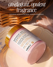 A jar of Truly Beauty’s Birthday Sex Shimmer Body Butter rests on a cream plate, with a woven basket and pink cloth behind it. The label features saffron, jasmine, and patchouli for an illuminating, hydrating glow.