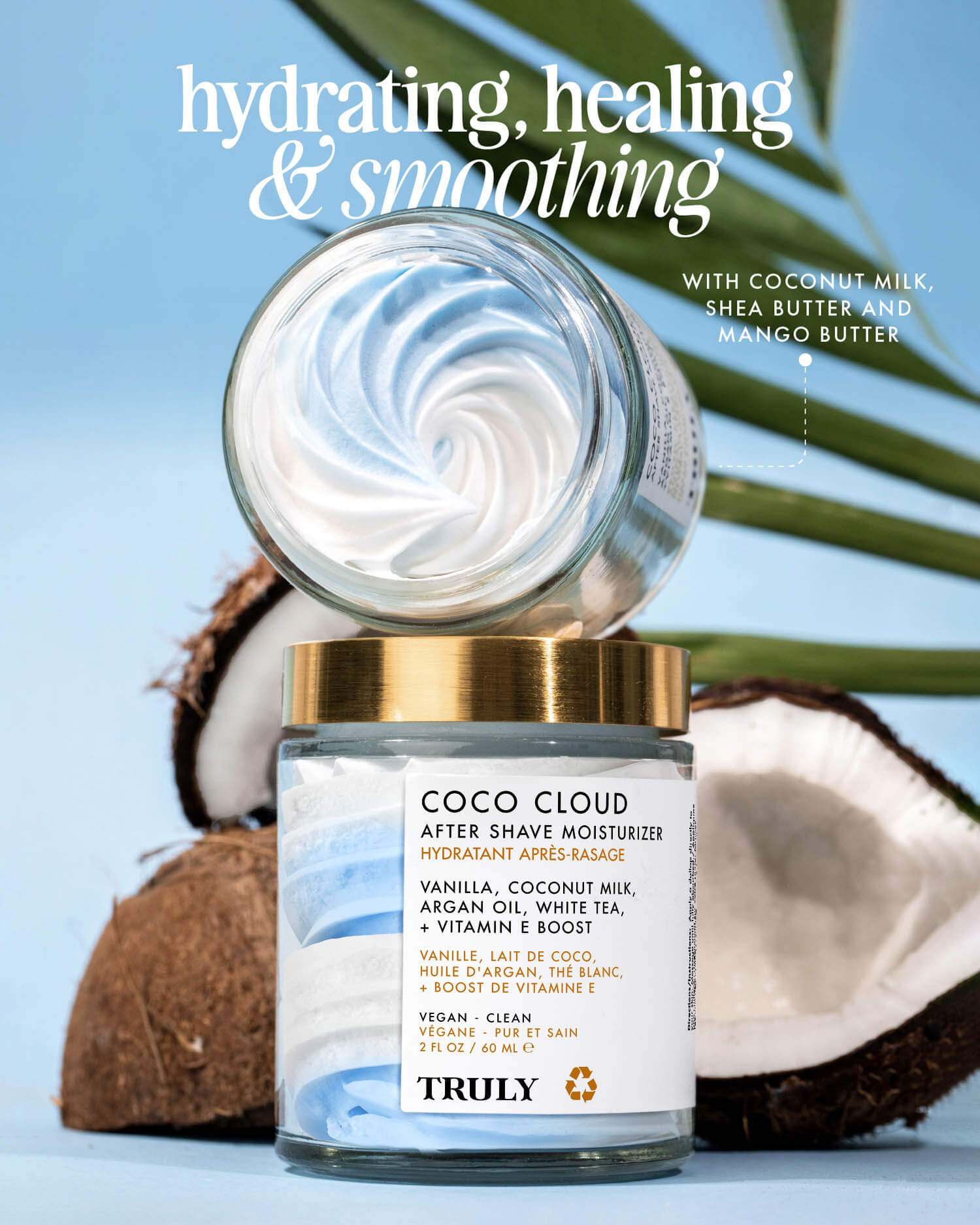 An open jar of Truly Beauty’s Coco Cloud After Shave Moisturizer swirls white and blue cream, placed beside a halved coconut. Infused with coconut milk for hydration, healing, and smoothing benefits.