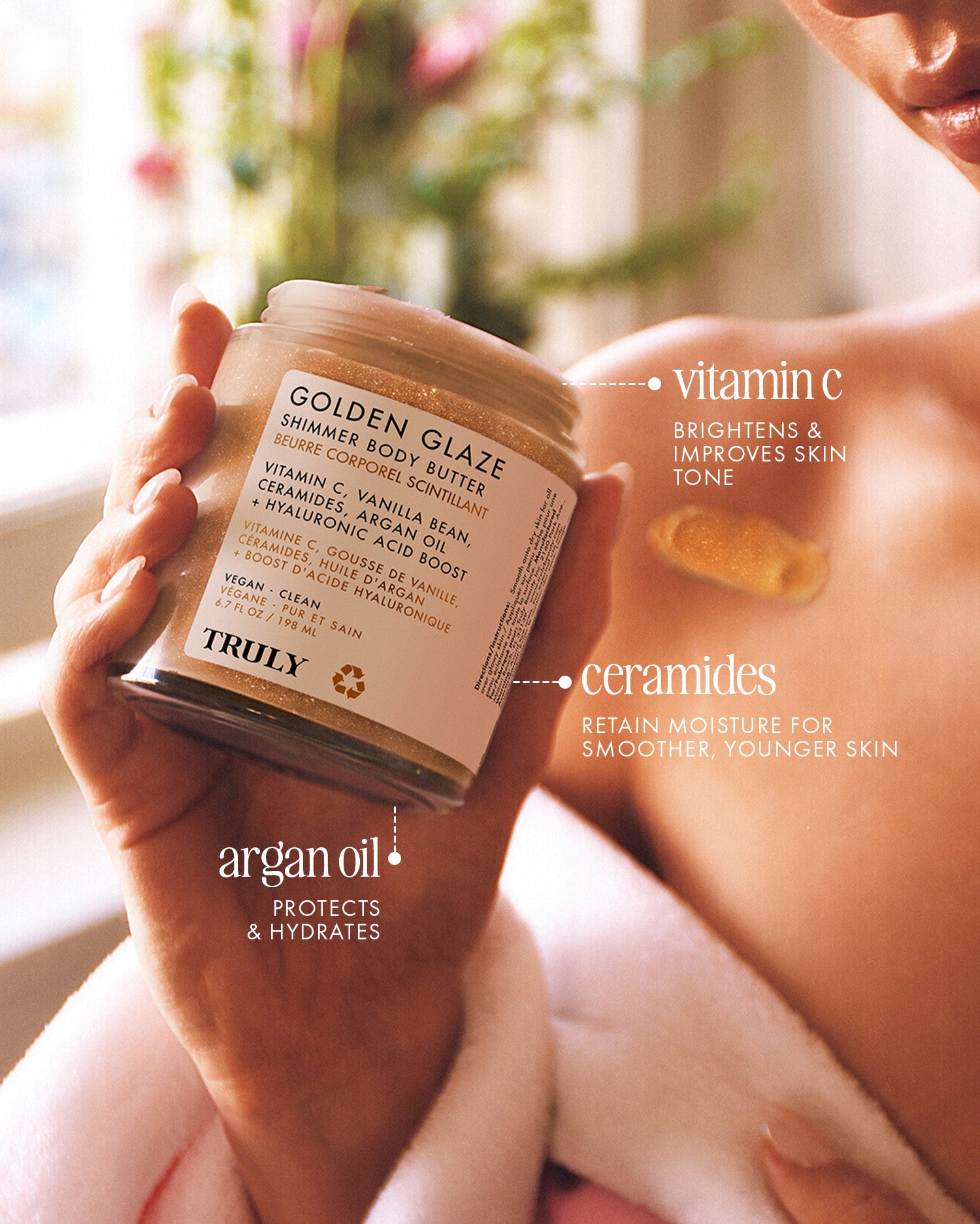A person applies TRULY Beauty’s Golden Glaze Luxury Trio to their shoulder, featuring vitamin C (brightens), ceramides (lock in moisture), and argan oil (protects and hydrates) for radiant, nourished skin.