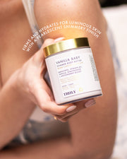 A person holds a jar from the Truly Beauty Vanilla Baby Luxury Trio. The label highlights bakuchiol, vitamin B3, and niacinamide. Text above reads: “Firms and hydrates for luminous, pearlescent skin with a warm vanilla scent.”.
