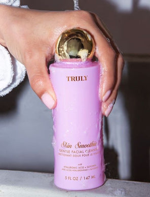 elderberry benefits for skin | closeup of truly beauty's cherry baby body oil held in front of woman's stomach