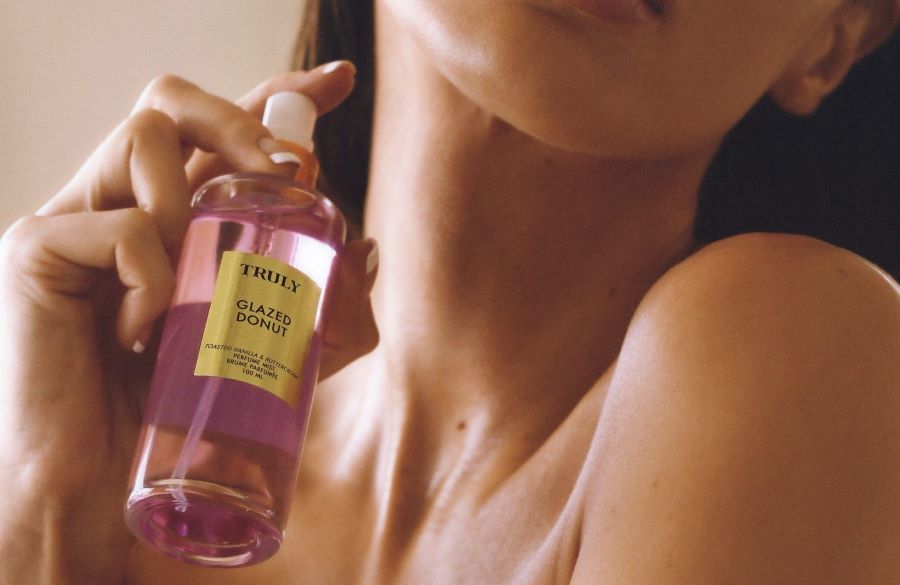 body mist vs perfume | Woman holding Truly's glazed donut perfume mist