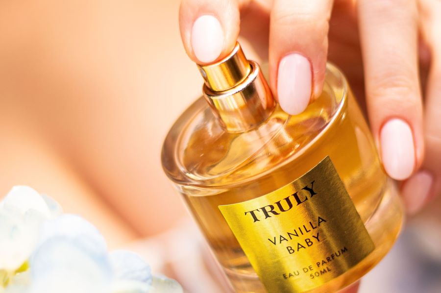 eau de toilette vs parfum | woman's hands spritzing Truly's vanilla baby eau de parfum