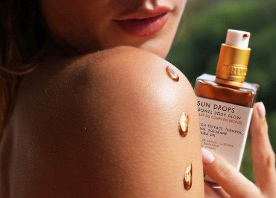 how to layer fragrances | Truly's birthday sex perfume mist held in front of table with wine glass