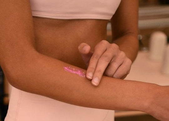 how to fix fake tan mistakes | side by side images showing closeup of Truly's Sun Drops Bronze Body Glow in glass bottle next to person's upper body wearing black strapless top with visible tan
