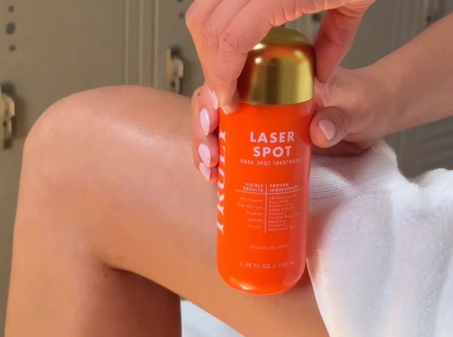dark inner thighs | A person holds an orange bottle of Truly Laser Spot Treatment next to leg