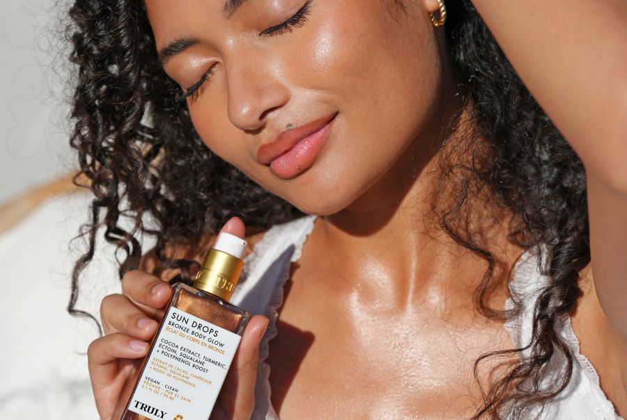 young woman with eyes closed holding bottle of Truly's sun drops