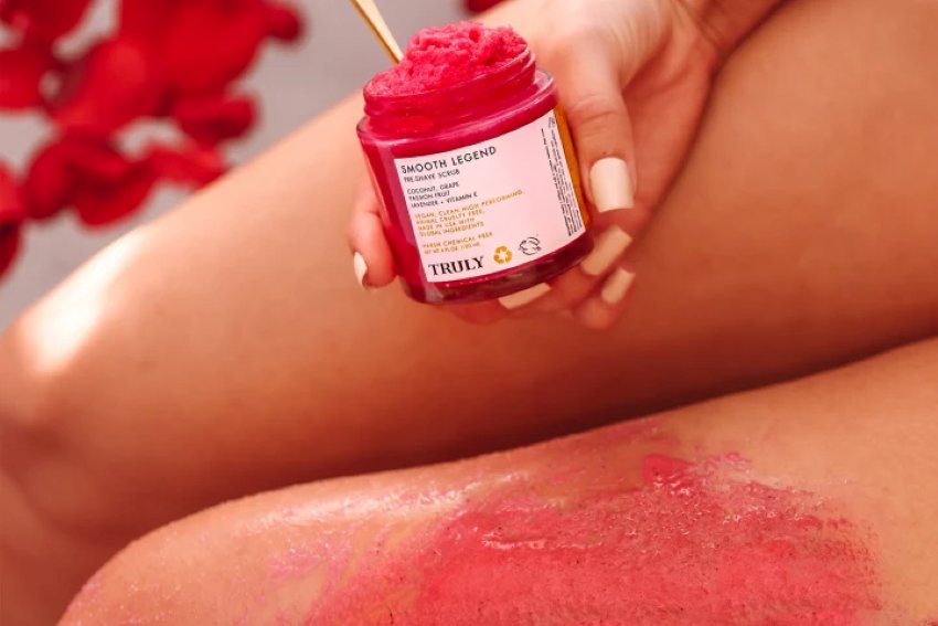 Person holding open jar of Truly Smooth Legend Sugar Scrub in front of legs | how to make sugar scrub