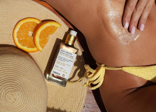 how to layer fragrances | Truly's birthday sex perfume mist held in front of table with wine glass