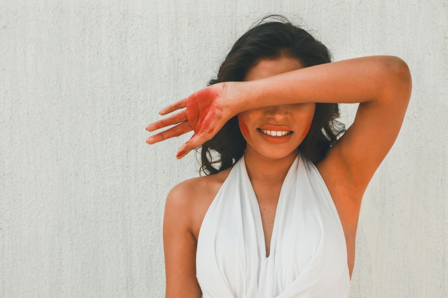Itchy Armpits After Shaving | young woman in white dress covering eyes with arm