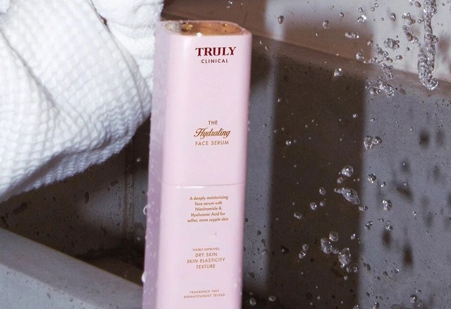 what is niacinamide for skin | closeup of a pink cosmetic bottle with gold writing - Truly clinical The Hydrating Face Serum with niacinamide and hyaluronic acid 