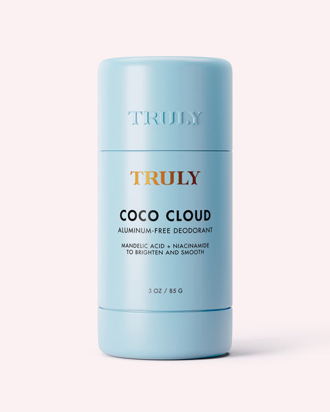 A light blue cylindrical stick of Truly Beauty Coco Cloud Ingrown Prevention and Brightening Deodorant, 3 oz, stands upright on a light background. It’s aluminum-free and contains mandelic acid and niacinamide to brighten and smooth skin discoloration.