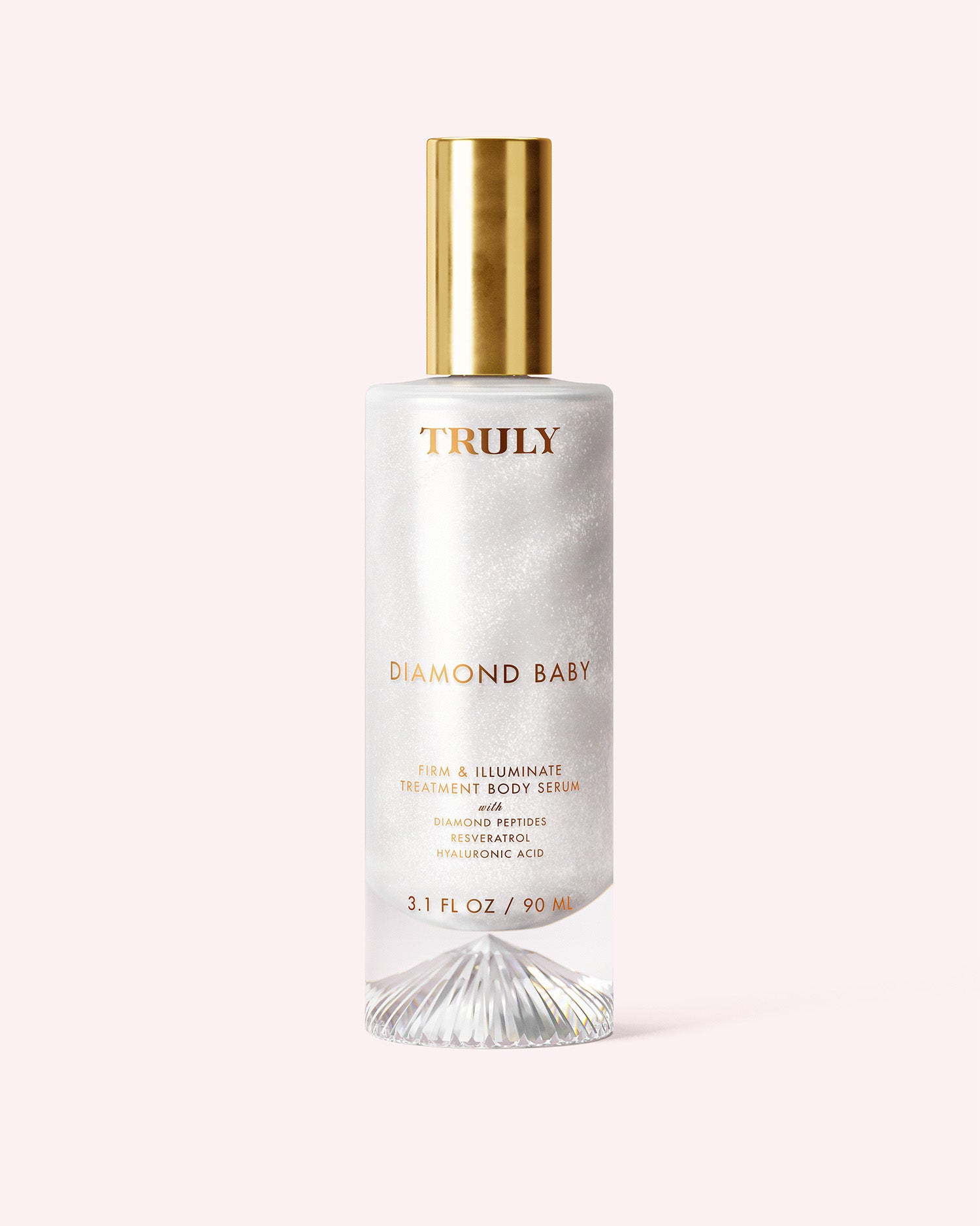 A bottle of Truly Beauty Diamond Baby Treatment Body Serum with a gold cap, clear glass, and iridescent white liquid features diamond peptides for glowing skin—displayed against a pale pink background.