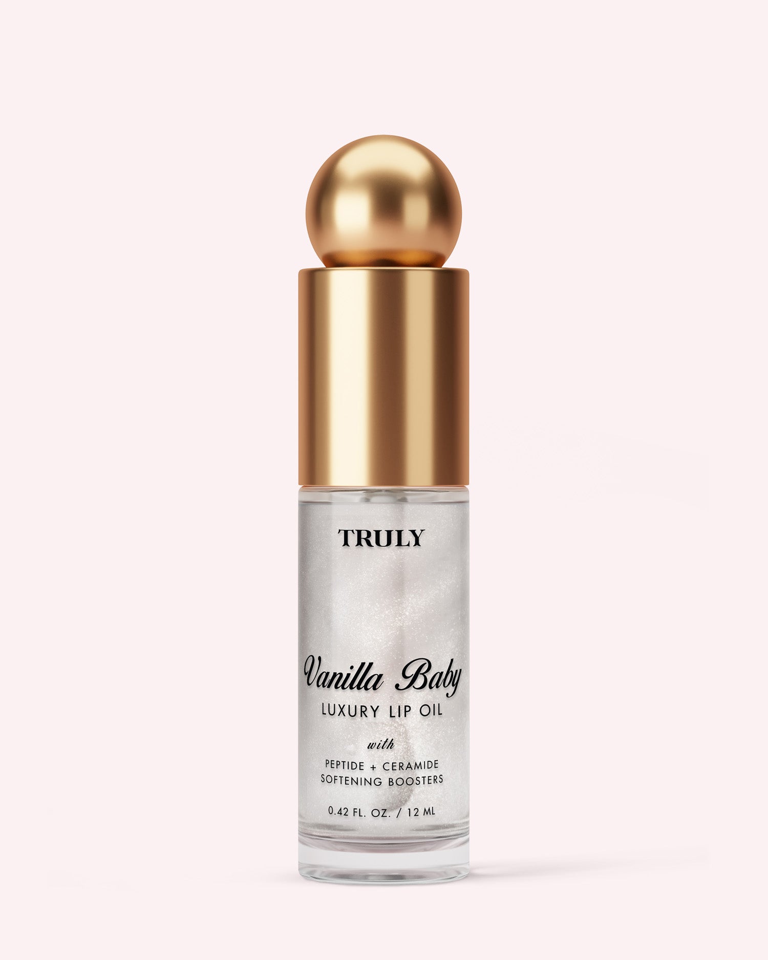 A clear 0.42 fl oz (12 ml) bottle of Truly Beauty Luxury Peptide Lip Oil with a gold cap and round top sits against a light pink background. The label highlights peptide and ceramide softening boosters.