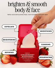 A hand peels a textured exfoliating pad from a red container labeled 'TRULY STRAWBERRY BLOSSOM'. The image features text callouts for 'EXFOLIATE', 'SMOOTHING', 'BRIGHTENING', 'CLEARING', 'REFINING', and 'RESURFACING', with fresh strawberries arranged at the base on a clean white background.
