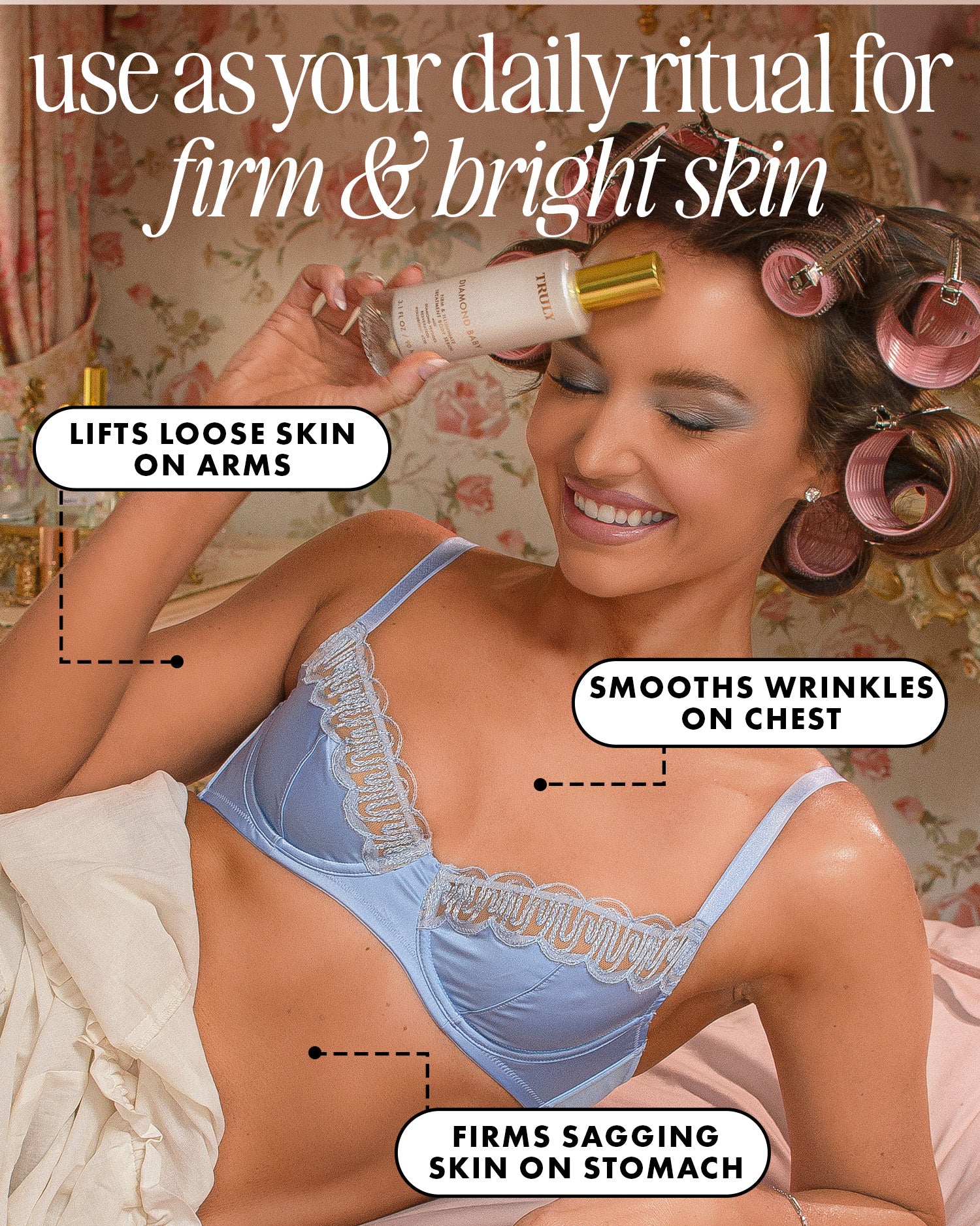 A smiling woman in a blue bra and hair rollers applies Truly Beauty's Diamond Baby Treatment Body Serum to her forehead. Text highlights anti-aging benefits: lifts loose arm skin, smooths chest wrinkles, and firms sagging stomach skin.