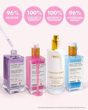 Four TRULY skincare serum bottles in assorted colors (lavender, pink, white, and light blue) lined up on a pale pink background, with four pink circular callouts at the top highlighting key product benefits.