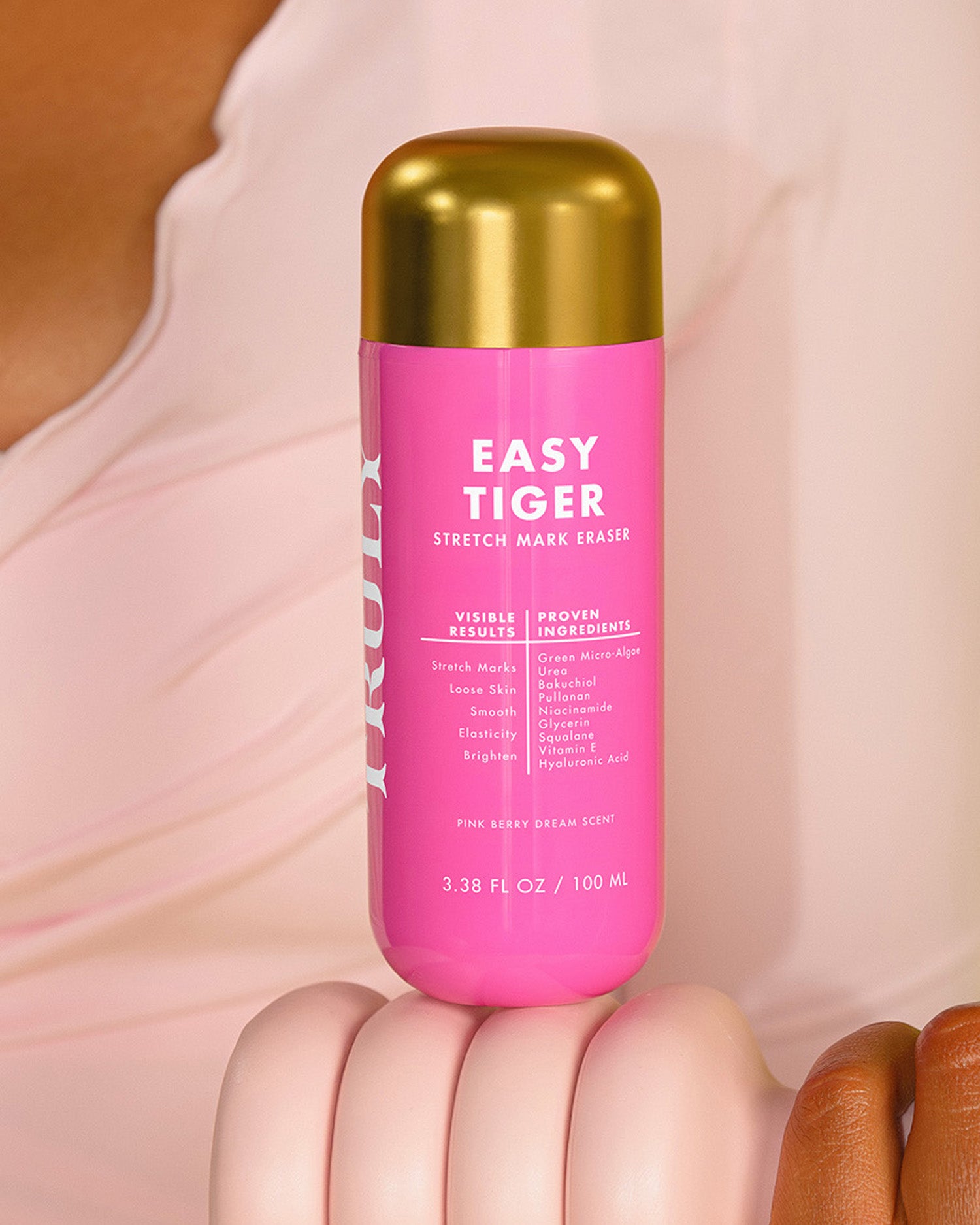 Pink bottle labeled 'Easy Tiger' held by a person with a blurred background