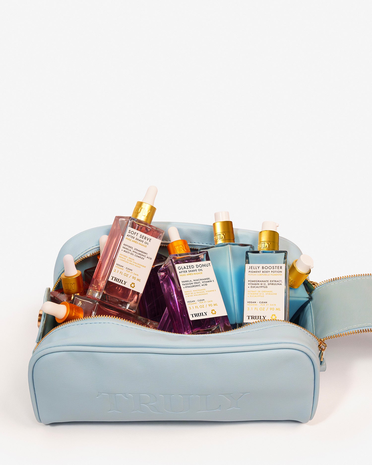 A light blue zippered bag featuring a variety of colorful serum bottles from Truly Beauty’s After Shave Oils Collection, each with a dropper lid and unique label—plus, take advantage of a limited-time buy one get one free offer on select after shave oils.