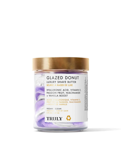 A clear jar of Truly Beauty Glazed Donut Luxury Shave Butter with swirled purple and white cream, gold lid, and label. This 8 fl oz hydrating shave butter contains hyaluronic acid and is made with vegan, clean ingredients.