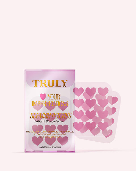 A package of Truly Beauty #Heart Your Imperfections Blemish Patches, featuring pink heart-shaped patches next to the pink and gold detailed box—a cute addition to your skincare routine.
