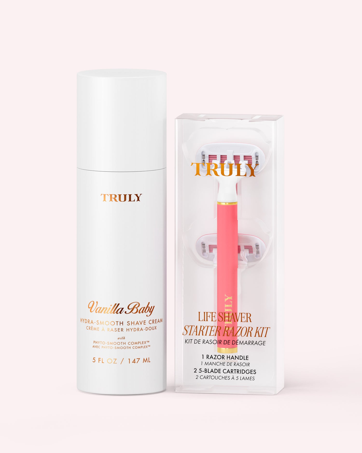 A white bottle of Truly Beauty Hydra-Smooth Shave Set cream next to a clear box containing a pink razor handle and two replacement cartridges.