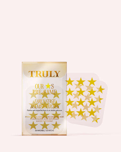 A package of Truly Beauty’s Our Stars Pre-Game Blemish Patches features gold star-shaped hydrocolloid patches visible through a clear front window, with more star patches shown to the right of the packaging.