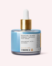 A blue bottle of Truly Beauty’s Glacial Glaze Hydrate + Replenish Face Serum with a gold dropper lid, labeled Hyaluronic Acid + Glycerin and 3.4 fl oz / 100ml, is shown against a pale background—formulated to boost skin elasticity and provide intense hydration.