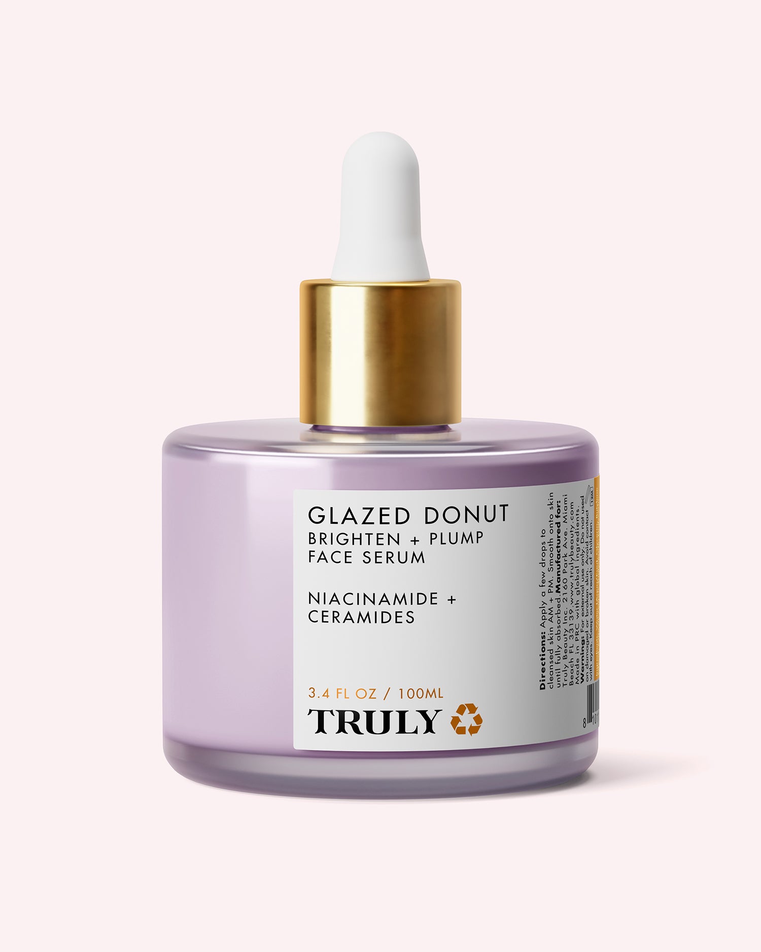 A lavender glass bottle of Truly Beauty Glazed Donut Brighten + Plump Face Serum, featuring a gold and white dropper cap. The label showcases its hydrating formula with powerhouse ingredients like niacinamide and ceramides, and reads “BRIGHTEN + PLUMP.” Perfect for achieving Glazed Donut Skin, this bottle contains 3.4 fl oz (100 ml) of serum.