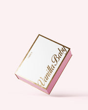 The Truly Beauty Vanilla Baby PR Box is a pink and white rectangular box with gold edges and 