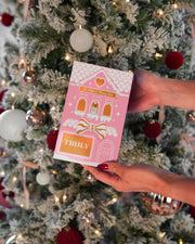 Hands holding the Truly Beauty 10 Days of Luxury Advent Calendar in front of a decorated Christmas tree—an ideal holiday-themed luxury skincare gift or Beauty Advent Calendar.