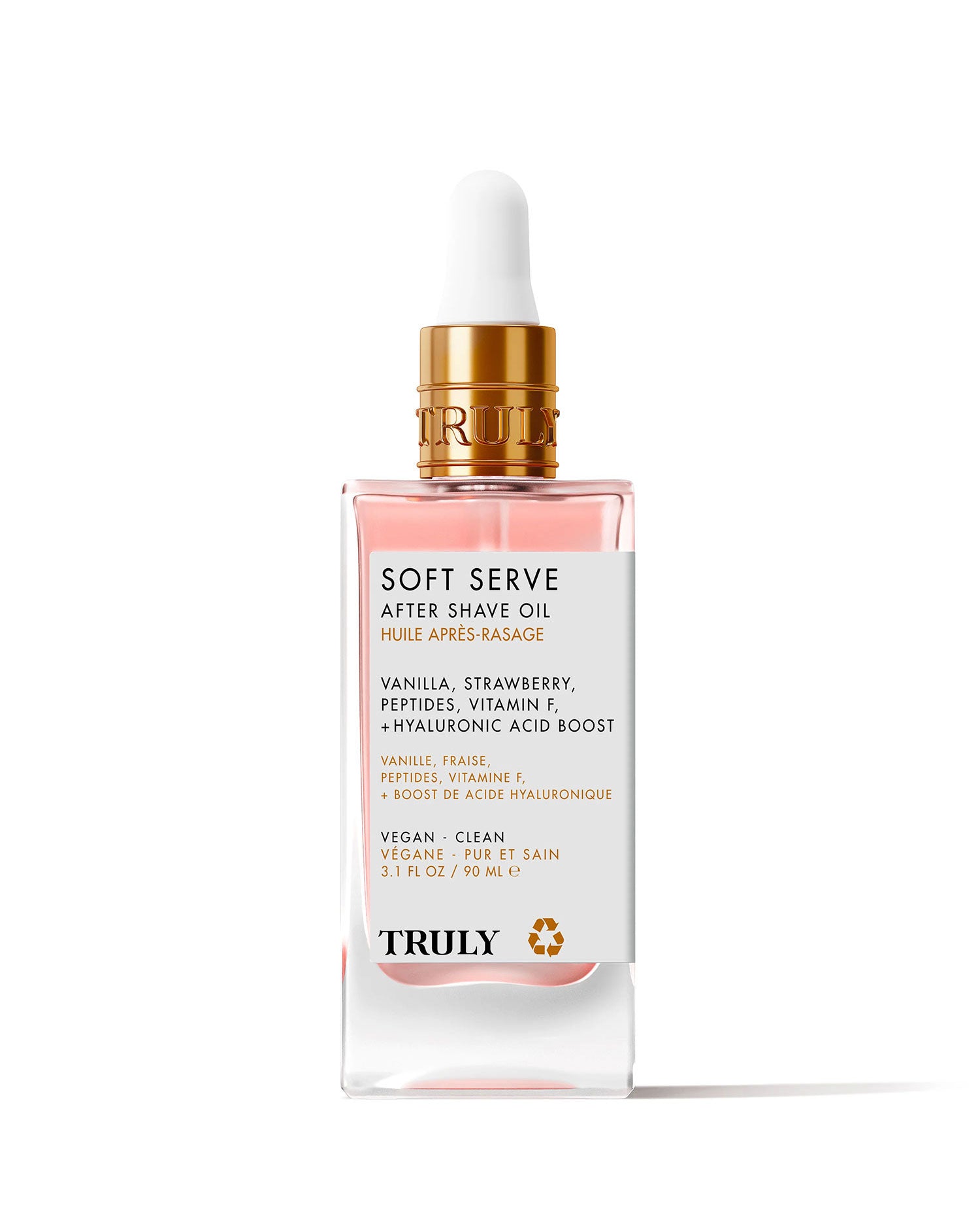 A pink and clear glass dropper bottle labeled Glazed Donut After Shave Oil, highlighting skin-smoothing niacinamide, vitamin E, and hyaluronic acid, is shown on a light pink background.
