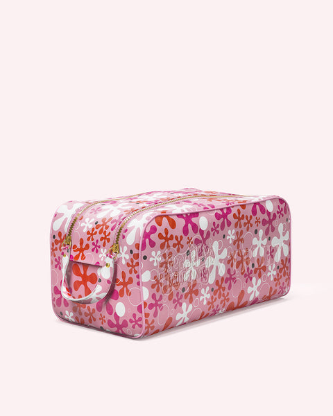 The SpongeBob Floral Vanity Case by Truly Beauty is a rectangular vegan leather cosmetics bag in pink and white, featuring a retro floral pattern with red, orange, and pink accents.