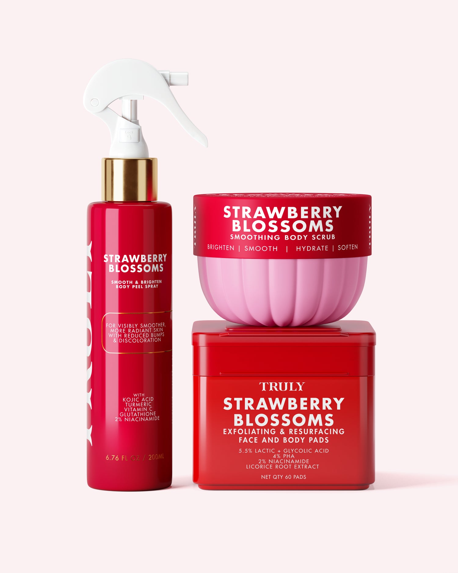 Experience Truly Beauty’s Strawberry Blossoms Complete Collection—three strawberry-inspired skincare essentials designed to elevate your skin cycling routine. The collection features a vibrant red spray bottle, a body scrub jar with a pink lid (perfect for addressing keratosis pilaris), and a striking red box of exfoliating pads. Each product is elegantly detailed with white and gold lettering and beautifully arranged against a soft pink backdrop.