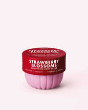 A pink and red container of Truly Beauty’s Strawberry Blossoms Smoothing Body Scrub, labeled with “Brighten, Smooth, Hydrate, Soften,” featuring a 10% PHA + AHA exfoliating formula for keratosis pilaris, displayed on a light pink background.