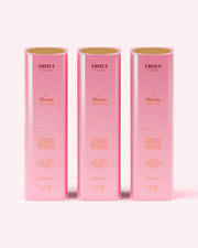 Three pink cylindrical bottles of Truly Beauty The Hydrating Body Serum, each with gold text, stand upright on a light pink background. Each hydrating serum contains hyaluronic acid and 3.1 fl oz (90 ml) of product.