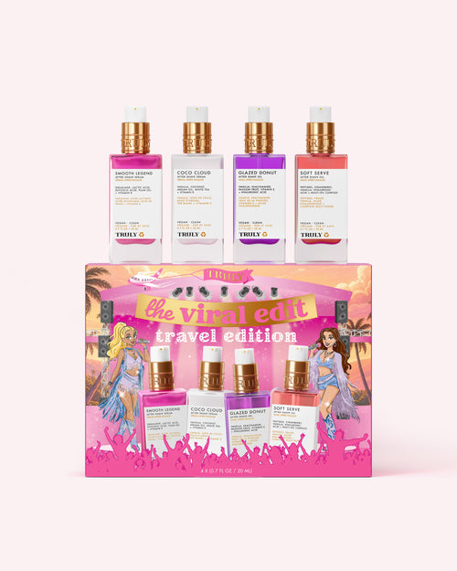A boxed fragrance set from TRULY called 'the viral edit travel edition' with four perfume bottles displayed above and on the front of the pink gift box. The set includes pink, white, purple, and coral/peach scents with metallic gold caps, shown on a pale pink background.