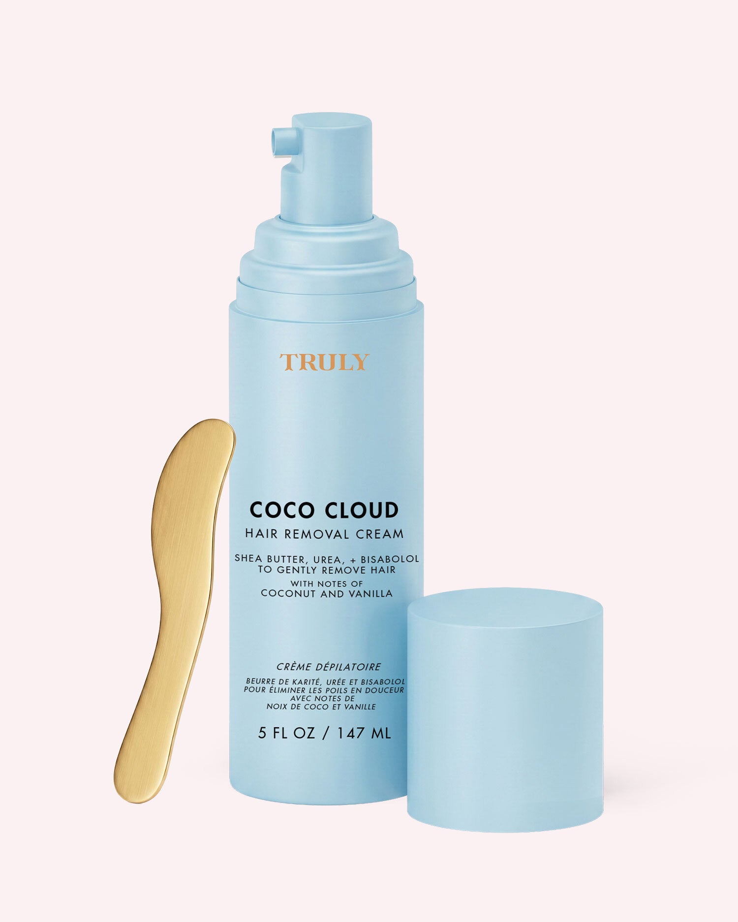 A light blue bottle of Truly Beauty’s Coco Cloud Hair Removal Cream is shown alongside a gold spatula and a matching blue cap, all beautifully displayed against a light background.