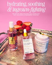 Three Truly Beauty Soft Serve Luxury Trio products on a silver tray with fresh strawberries; text highlights this hydrating, soothing bundle’s ingrown hair care. The pink background enhances the strawberry-scented after shave feel.